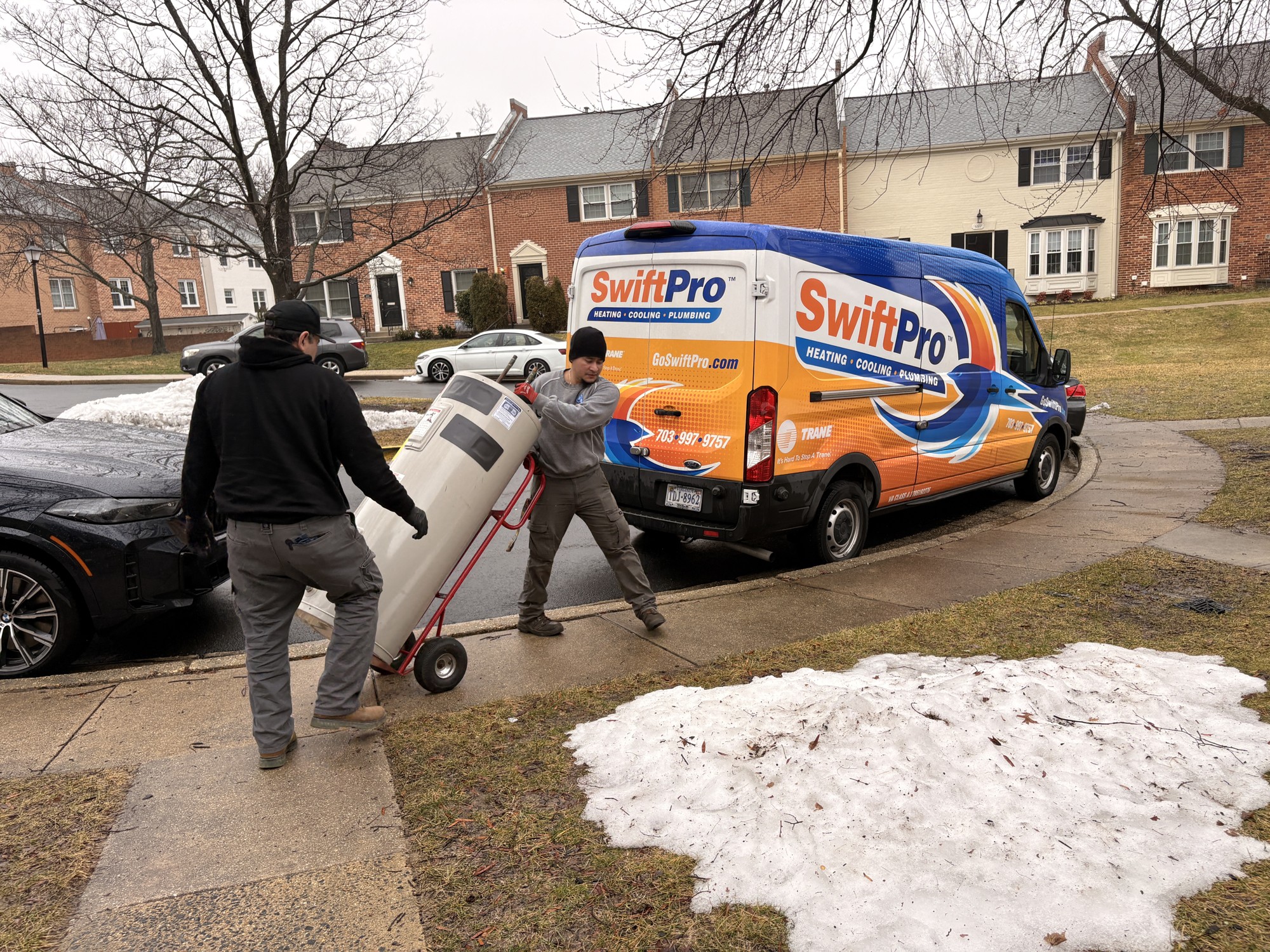 SwiftPro team moving a tank water heater